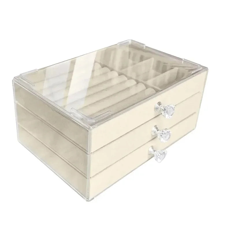 A clear acrylic jewelry organizer featuring multiple compartments and drawers, designed to neatly store and display rings, necklaces, bracelets, and earrings. Its transparent design allows for easy visibility of contents, while the compact structure fits seamlessly on a vanity or dresser, keeping accessories organized and easily accessible