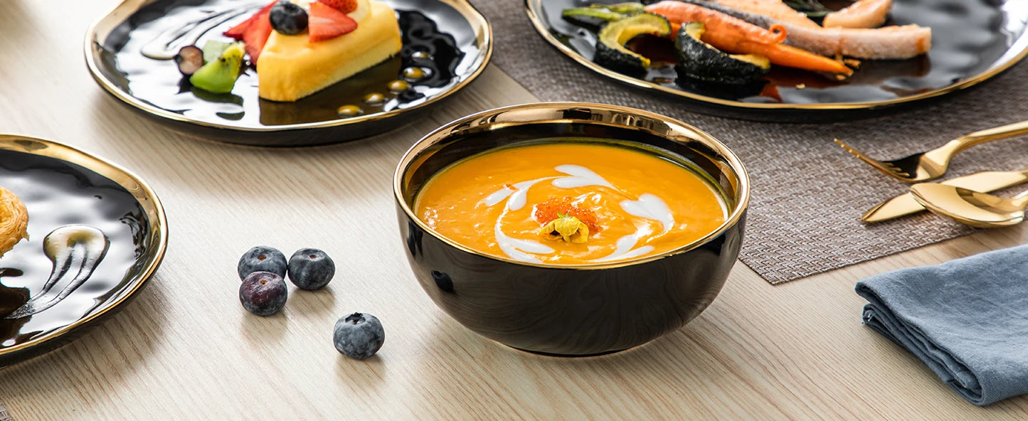 A sophisticated black porcelain dinnerware set featuring elegant gold trim accents. This set typically includes dinner plates, salad plates, bowls, and mugs, all crafted from high-quality porcelain. The combination of deep black hues with refined gold detailing adds a touch of luxury to both everyday dining and special occasions
