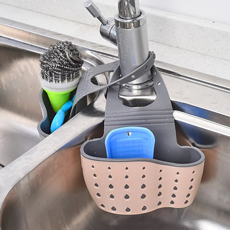 A double-layer sink hanging organizer made of durable materials, featuring two compartments for storing sponges, brushes, and other cleaning tools. Designed to hang over the sink or faucet, it provides convenient storage and quick drainage, keeping the countertop clutter-free
