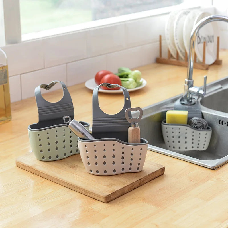A double-layer sink hanging organizer made of durable materials, featuring two compartments for storing sponges, brushes, and other cleaning tools. Designed to hang over the sink or faucet, it provides convenient storage and quick drainage, keeping the countertop clutter-free