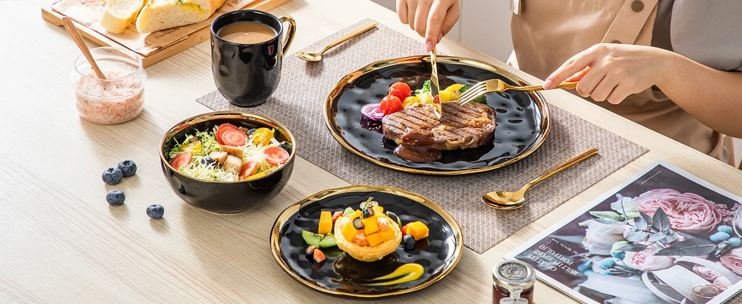 A sophisticated black porcelain dinnerware set featuring elegant gold trim accents. This set typically includes dinner plates, salad plates, bowls, and mugs, all crafted from high-quality porcelain. The combination of deep black hues with refined gold detailing adds a touch of luxury to both everyday dining and special occasions