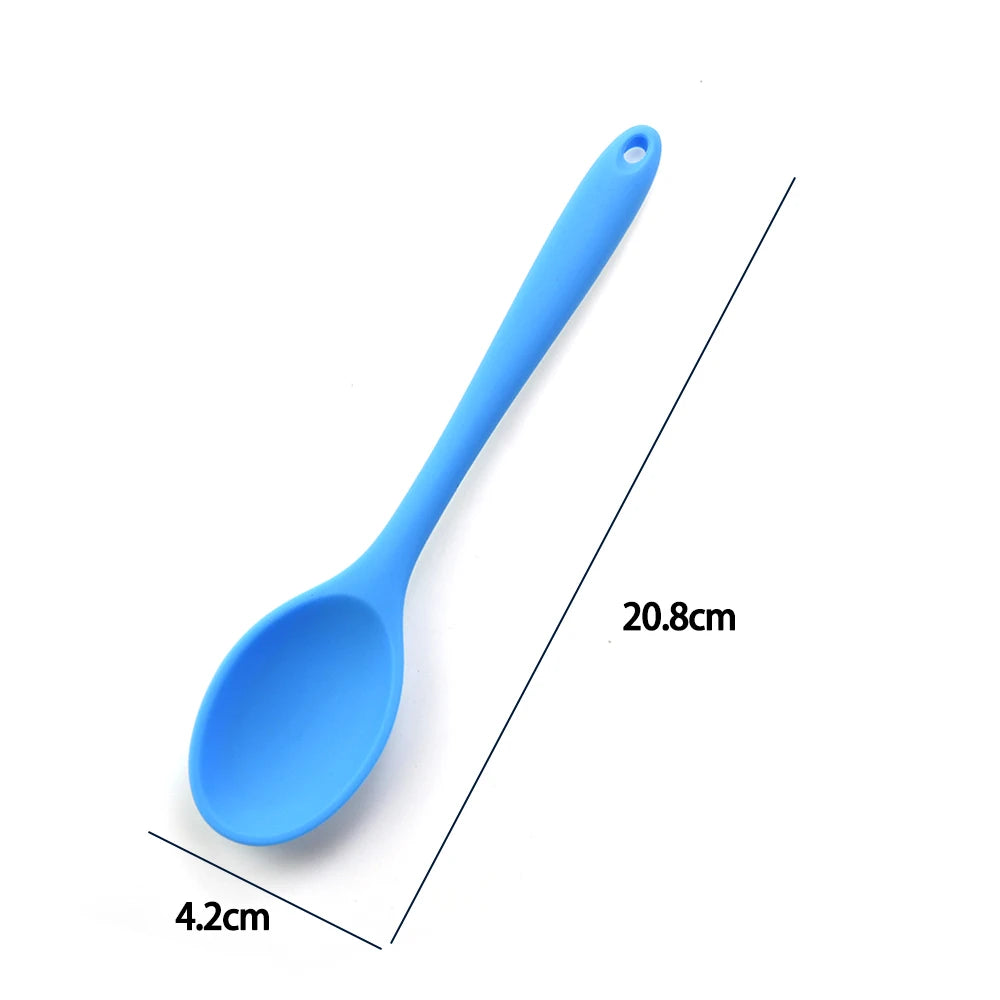 A soft silicone spoon designed for stirring, featuring a flexible, heat-resistant head that protects non-stick cookware. The ergonomic handle ensures a comfortable grip, making it ideal for mixing, scooping, and serving a variety of dishes