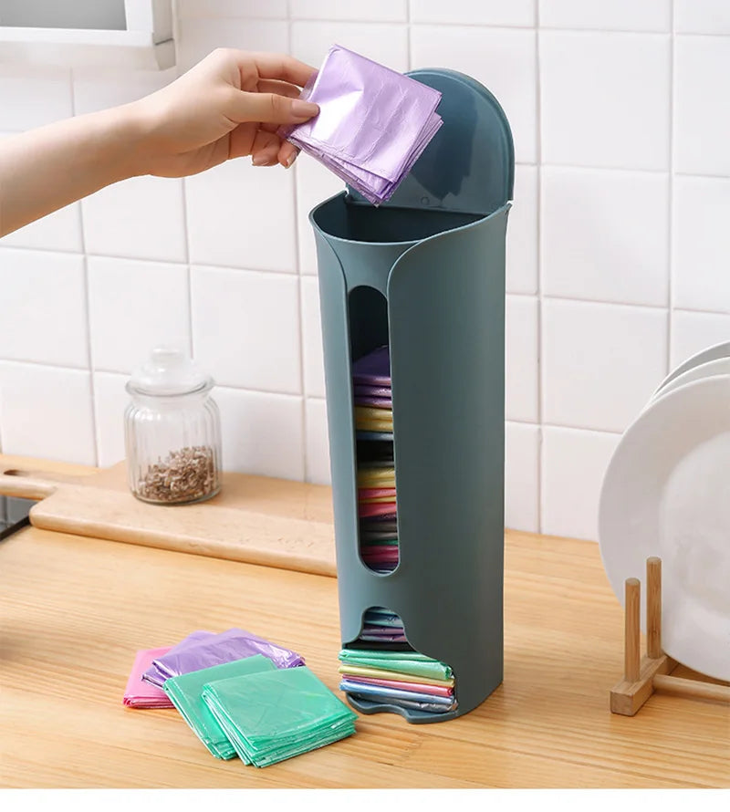 A wall-mounted plastic bag holder made of durable stainless steel with a sleek silver finish. Designed to neatly store and dispense plastic grocery bags, it features a top opening for easy insertion and a front slot for convenient retrieval, helping to keep your kitchen organized and clutter-free.