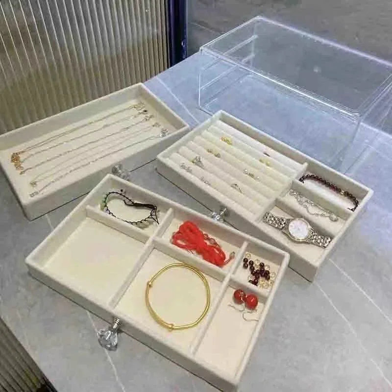 A clear acrylic jewelry organizer featuring multiple compartments and drawers, designed to neatly store and display rings, necklaces, bracelets, and earrings. Its transparent design allows for easy visibility of contents, while the compact structure fits seamlessly on a vanity or dresser, keeping accessories organized and easily accessible