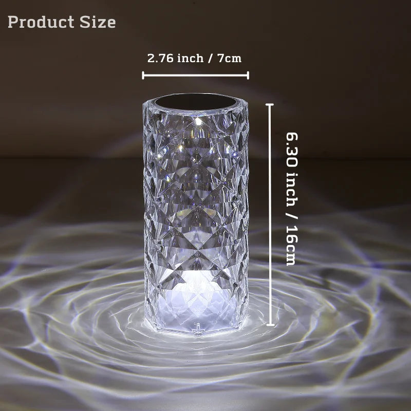 A crystal table lamp featuring a gleaming crystal base with intricate facets that refract light, complemented by an elegant lampshade. This decorative lighting piece adds a touch of sophistication and glamour to any room, creating a warm and inviting ambiance