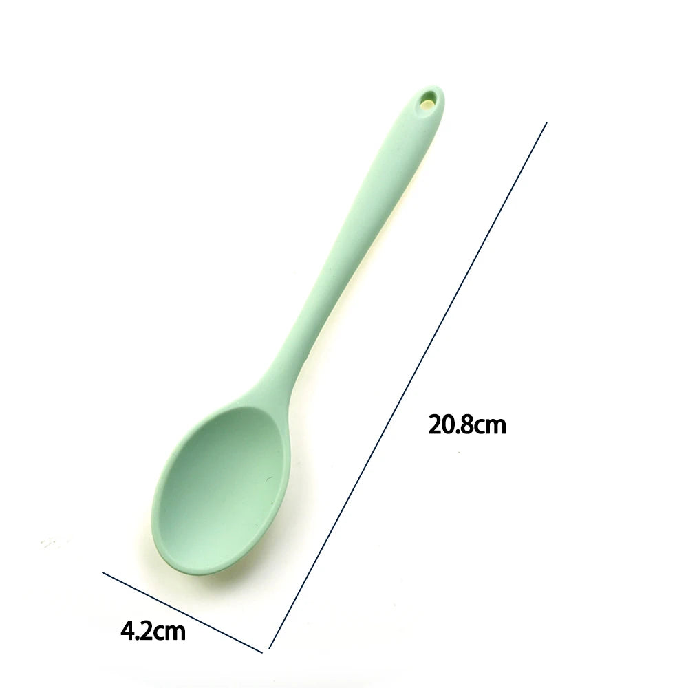 A soft silicone spoon designed for stirring, featuring a flexible, heat-resistant head that protects non-stick cookware. The ergonomic handle ensures a comfortable grip, making it ideal for mixing, scooping, and serving a variety of dishes