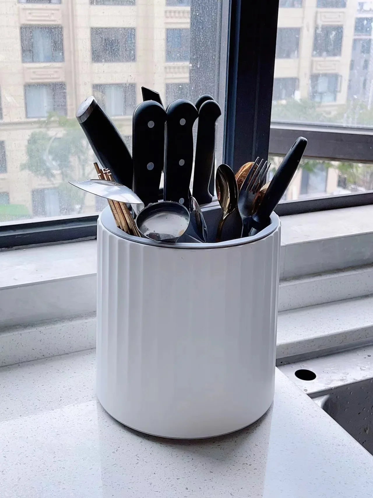 Multi-functional rotatable knife rack with a 360-degree rotating design, featuring multiple slots and compartments for organized storage of knives, cutting boards, and utensils, enhancing kitchen efficiency