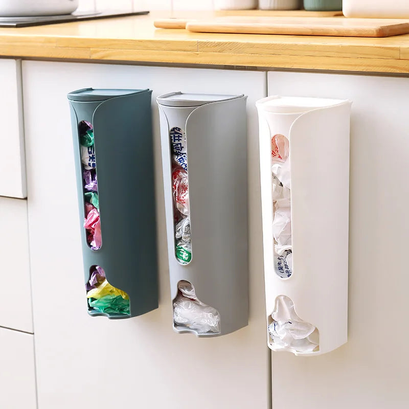 A wall-mounted plastic bag holder made of durable stainless steel with a sleek silver finish. Designed to neatly store and dispense plastic grocery bags, it features a top opening for easy insertion and a front slot for convenient retrieval, helping to keep your kitchen organized and clutter-free.