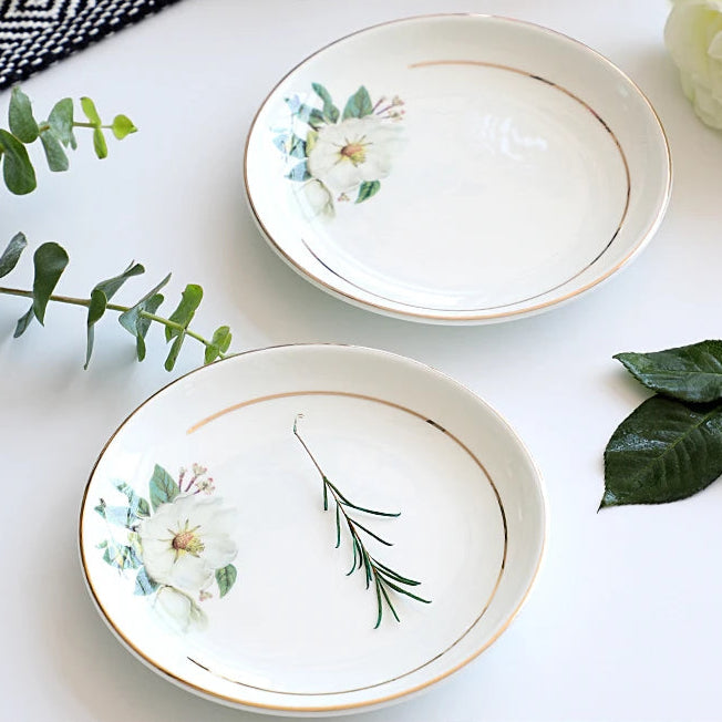 A set of bone china dinnerware comprising dinner plates, salad plates, bowls, and cups, all crafted from high-quality porcelain infused with bone ash. Renowned for its exceptional whiteness, translucency, and strength, bone china offers a luxurious feel and elegant appearance. This timeless collection is perfect for enhancing both everyday meals and special occasions