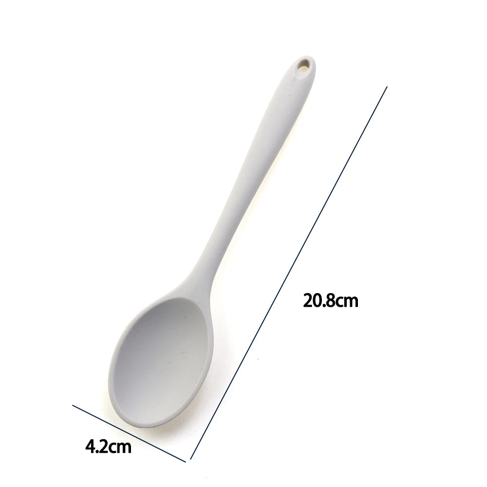 A soft silicone spoon designed for stirring, featuring a flexible, heat-resistant head that protects non-stick cookware. The ergonomic handle ensures a comfortable grip, making it ideal for mixing, scooping, and serving a variety of dishes
