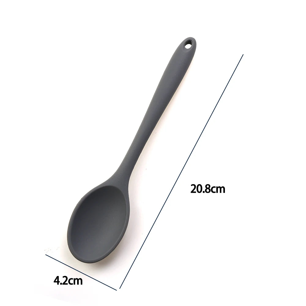 A soft silicone spoon designed for stirring, featuring a flexible, heat-resistant head that protects non-stick cookware. The ergonomic handle ensures a comfortable grip, making it ideal for mixing, scooping, and serving a variety of dishes