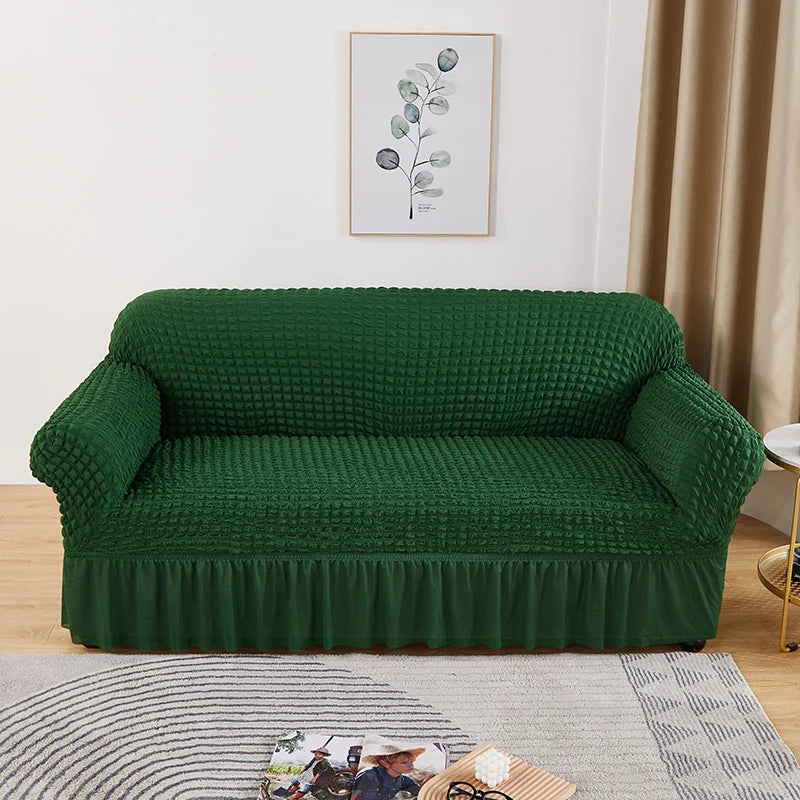 Stretchable sofa cover in a neutral tone, fitting snugly over a three-seater couch, providing protection and a refreshed look to the living room furniture