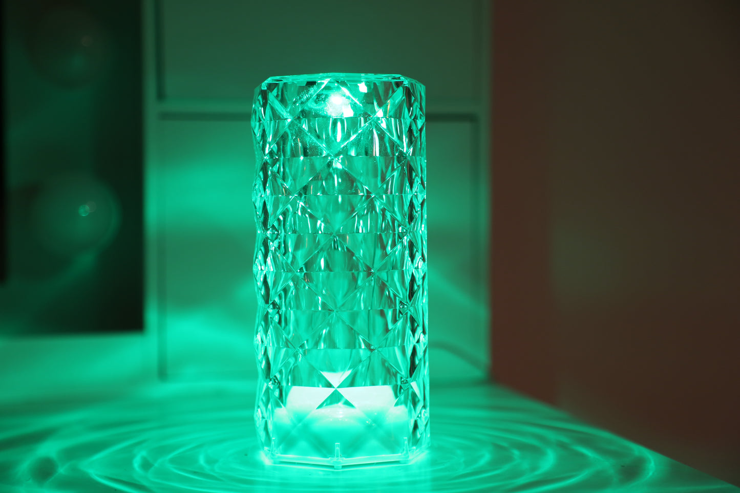 A crystal table lamp featuring a gleaming crystal base with intricate facets that refract light, complemented by an elegant lampshade. This decorative lighting piece adds a touch of sophistication and glamour to any room, creating a warm and inviting ambiance