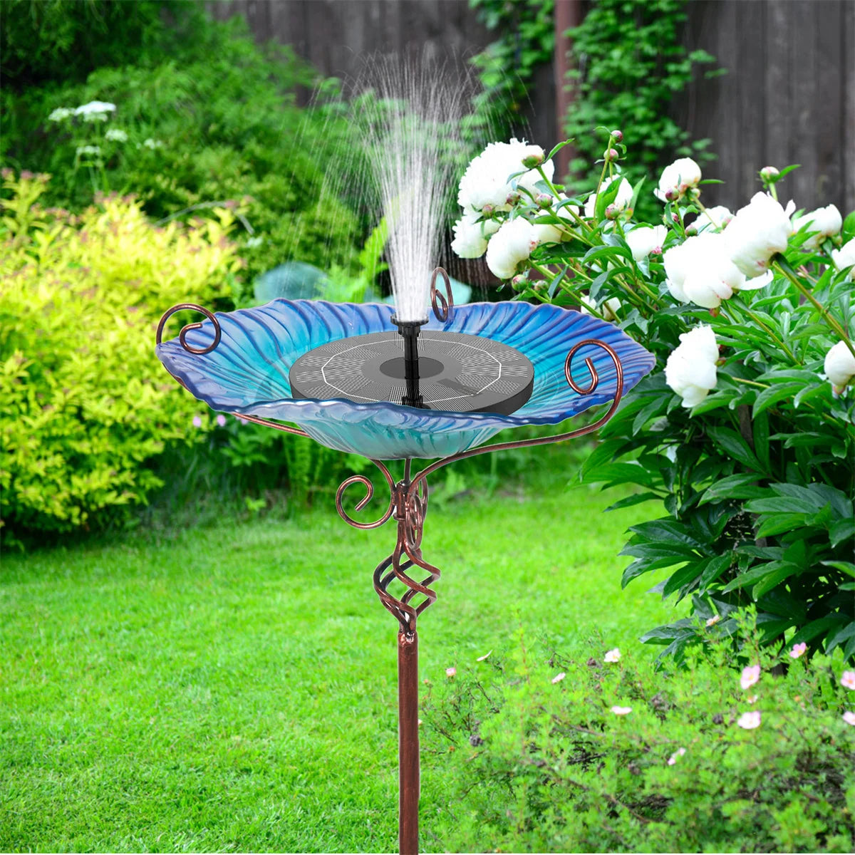A decorative garden birdbath featuring a glass bowl with a flower design, mounted on a tall pedestal. The vibrant colors and intricate patterns attract birds while adding a touch of elegance to outdoor spaces.