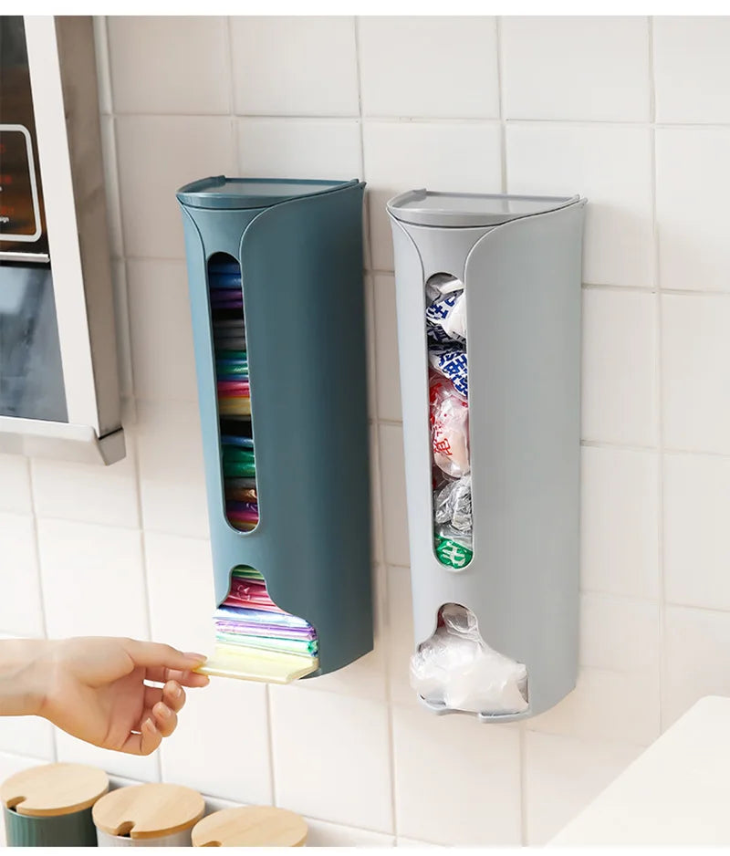 A wall-mounted plastic bag holder made of durable stainless steel with a sleek silver finish. Designed to neatly store and dispense plastic grocery bags, it features a top opening for easy insertion and a front slot for convenient retrieval, helping to keep your kitchen organized and clutter-free.