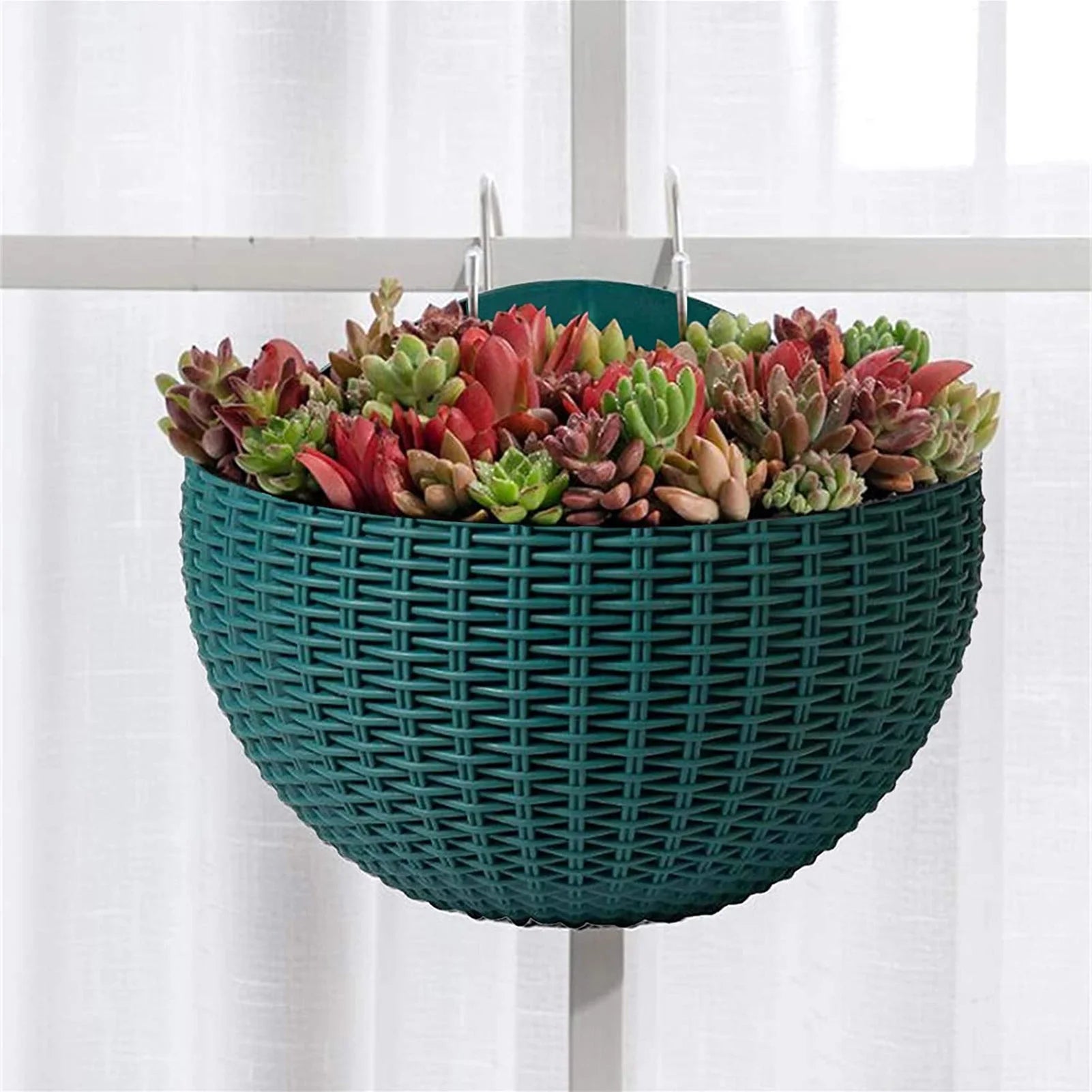 A durable plastic wall-mounted hanging planter in a half-round design, securely attached to a balcony railing. It is filled with vibrant blooming flowers, adding a touch of nature and color to the outdoor space.