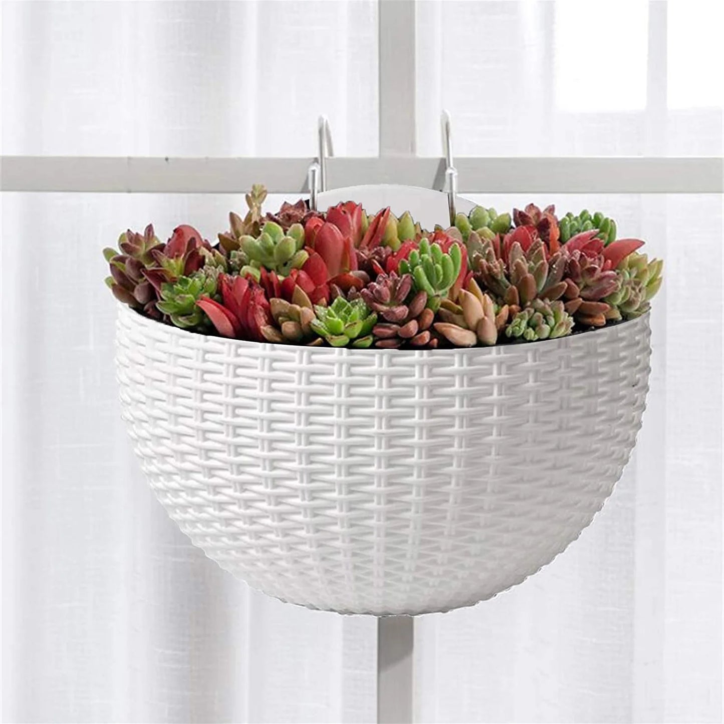 A durable plastic wall-mounted hanging planter in a half-round design, securely attached to a balcony railing. It is filled with vibrant blooming flowers, adding a touch of nature and color to the outdoor space.