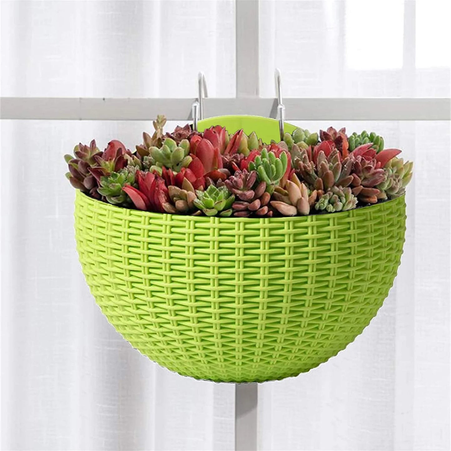 A durable plastic wall-mounted hanging planter in a half-round design, securely attached to a balcony railing. It is filled with vibrant blooming flowers, adding a touch of nature and color to the outdoor space.