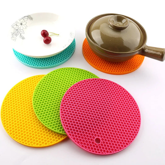 A round, heat-resistant silicone trivet designed to protect countertops and tables from hot cookware. Featuring a non-slip surface and flexible material, it is ideal for placing hot pots, pans, and dishes, ensuring safety and preserving your kitchen surfaces