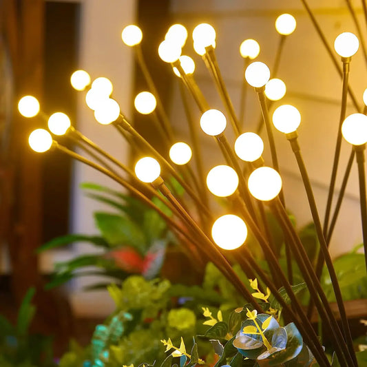 A collection of solar-powered garden lights illuminating a pathway at dusk. The lights, designed in various styles such as lanterns, stakes, and string lights, harness sunlight during the day and emit a warm, inviting glow in the evening, enhancing the ambiance of the outdoor space